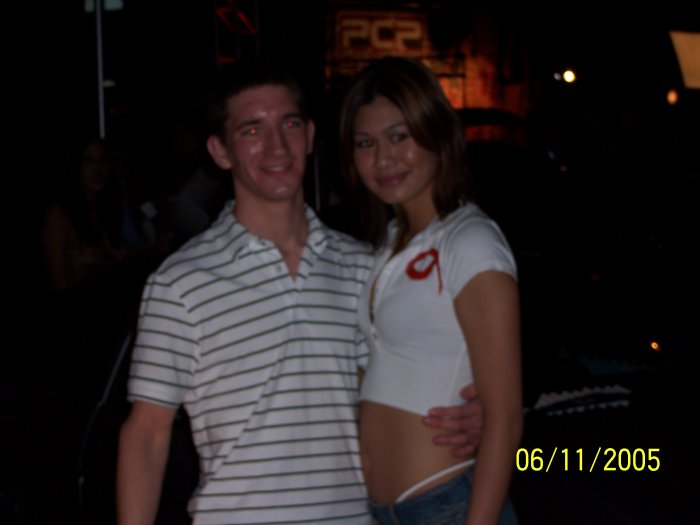 Man and woman posing for a photo at night. Date stamp reads 06/11/2005