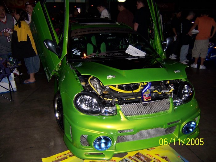 Green car with butterfly doors open, engine exposed. Date stamp says 06/11/2005
