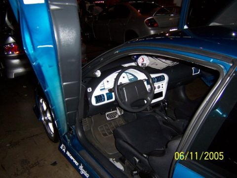 2005 Ford Focus - The interior of a blue car features custom gauges and suicide doors, with a date stamp of 06/11/2005 visible.