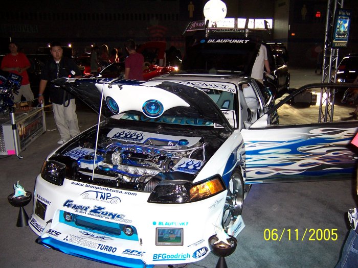 modified car with flames on door, open hood showing engine, and custom interior. Date stamp shows 06/11/2005