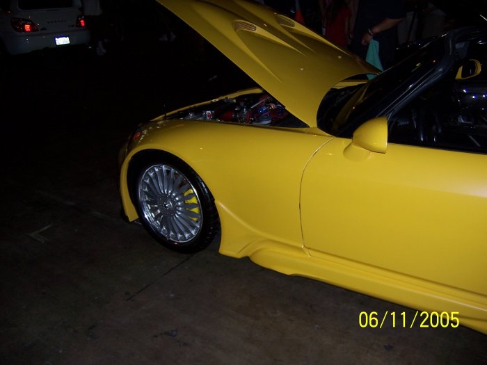 Yellow sports car, front quarter view, hood open showing engine, custom body kit, aftermarket wheels. Date stamp 06/11/2005