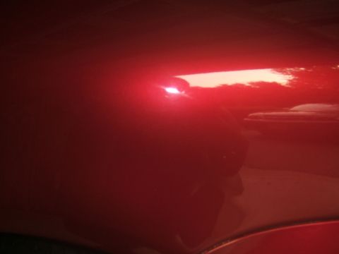 1998 Ford Taurus - Reflection of the sunset on the shiny red paint of a car's exterior.