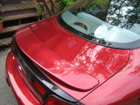 1998 Ford Taurus - The rear of a red 1998 Ford Taurus shows its spoiler and trunk lid.
