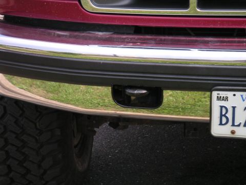 1994 Ford Bronco - Close-up of a red truck's front bumper, revealing a tow hook and a Virginia license plate.