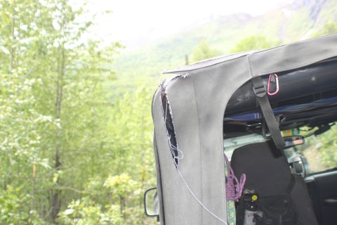 2003 Jeep TJ - A close-up view of a ripped soft top on a Jeep, revealing damage to the fabric.