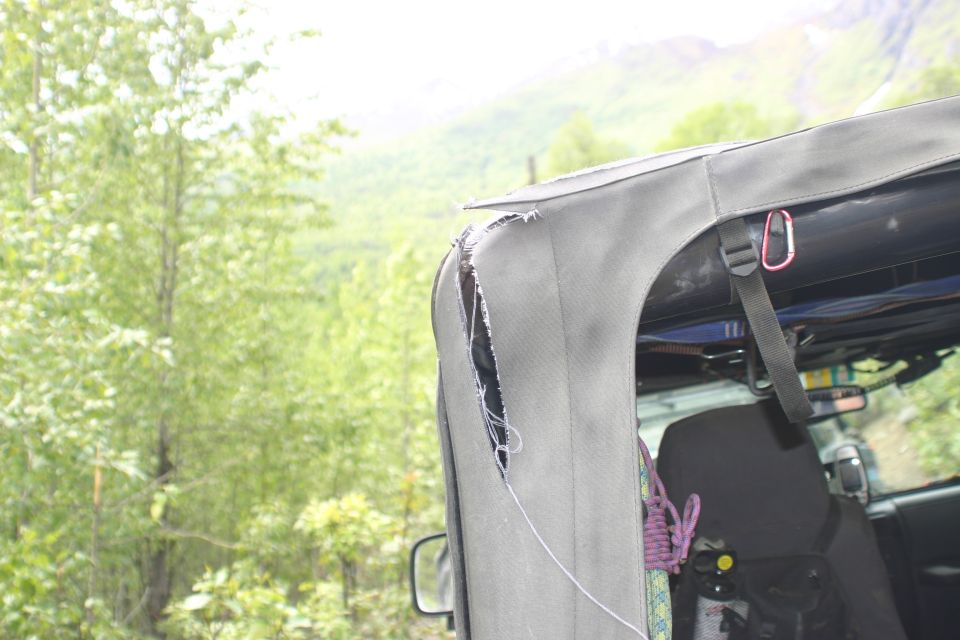Torn soft top on a Jeep, showing ripped fabric and interior