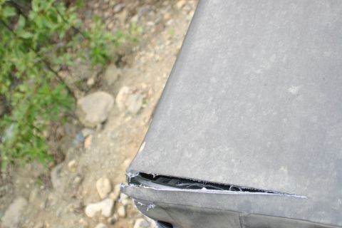 2003 Jeep TJ - Damage to the soft top of a Jeep, with visible tearing and fraying of the material.