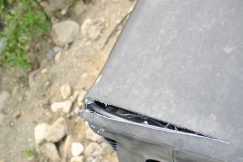 2003 Jeep TJ - A close-up shows a significant rip in the fabric of a vehicle's soft top.