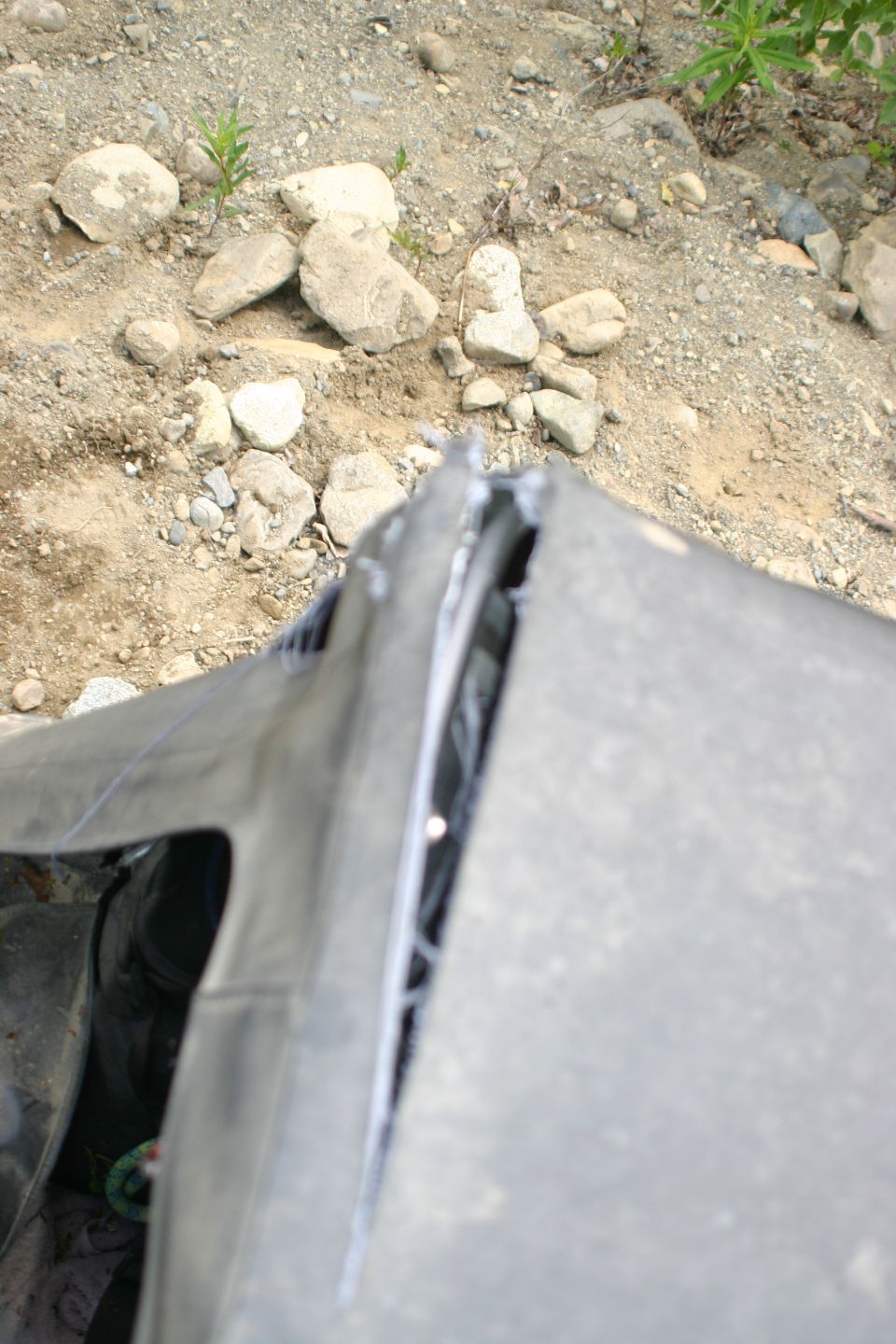 Torn black soft top on a vehicle, showing ripped seams and exposed interior