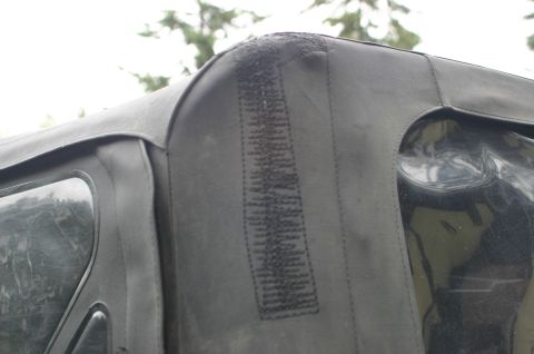 2003 Jeep TJ - Detail of a Jeep soft top corner, showing stitching and a clear window section.