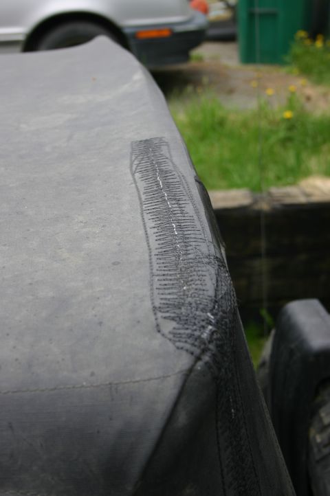 2003 Jeep TJ - A gray soft top shows a visible repair patch with stitching on its surface.
