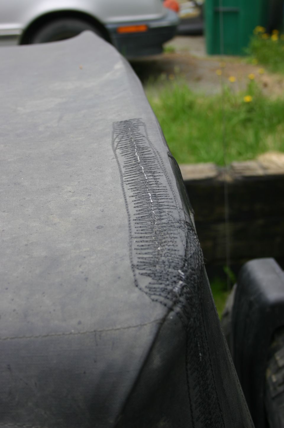 Gray soft top with a stitched repair patch visible on the right side