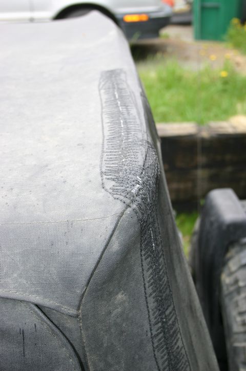 2003 Jeep TJ - Soft top corner shows evidence of repair work with visible stitching and adhesive.