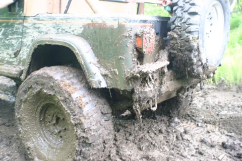 2003 Jeep TJ - This 2003 Jeep TJ is deeply stuck in mud, showing its rear end and spare tire.
