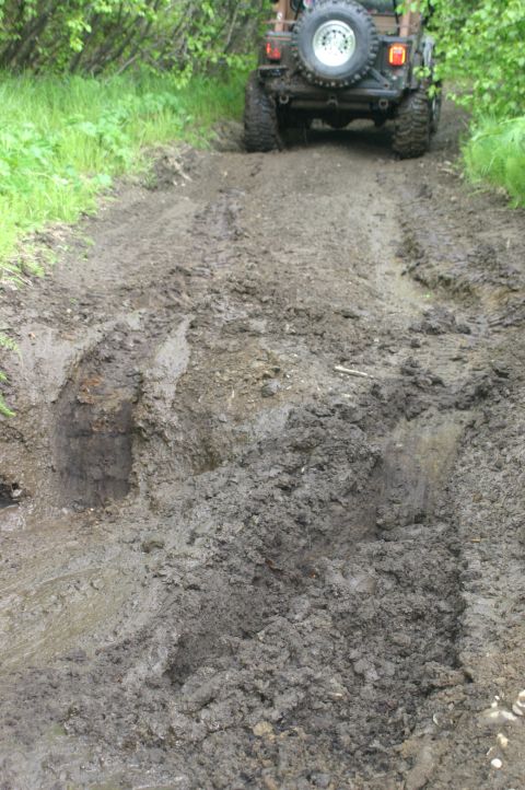 2003 Jeep TJ - A 2003 Jeep TJ navigates a challenging muddy off-road path.