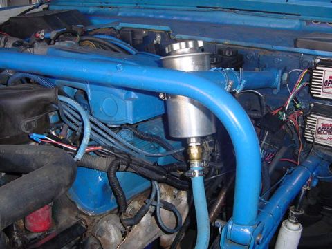 1971 Ford Bronco - Close-up of a vehicle's engine bay, custom blue paint and aftermarket ignition components.