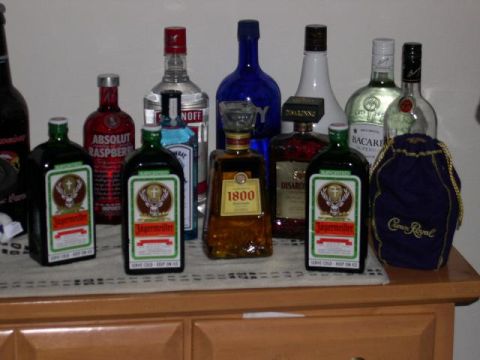 1997 Ford Probe - A variety of alcoholic beverages are displayed on a wooden surface, several bottles of Jägermeister and other popular brands.