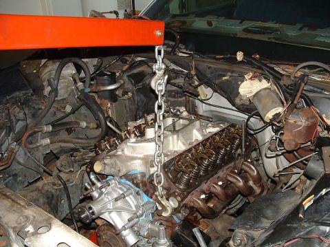 1985 Ford Crown Victoria LTD - Engine bay during a repair or swap, with the engine hoist engaged.