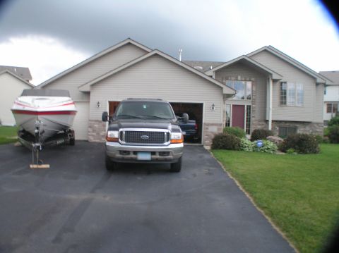 2000 Ford Excursion - Ford Excursion and boat trailer parked in driveway in front of a suburban house.