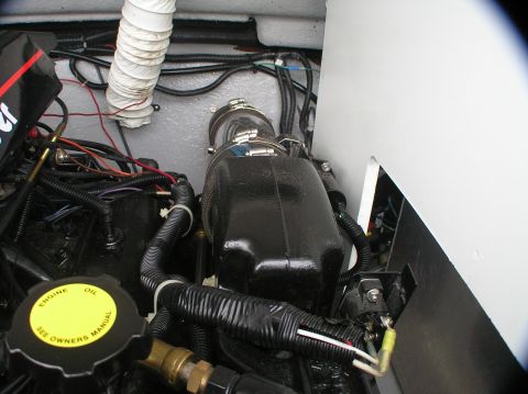 1997 Crownline 266 CCR - Close-up view of a boat's engine compartment, showing wiring, hoses, and engine components.