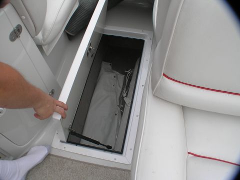 1997 Crownline 266 CCR - Interior view of a boat's storage compartment with a folded cover inside.