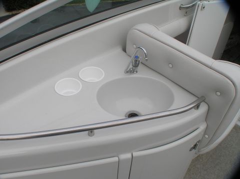 1997 Crownline 266 CCR - Close-up of a boat's interior sink area, a faucet and cup holders.