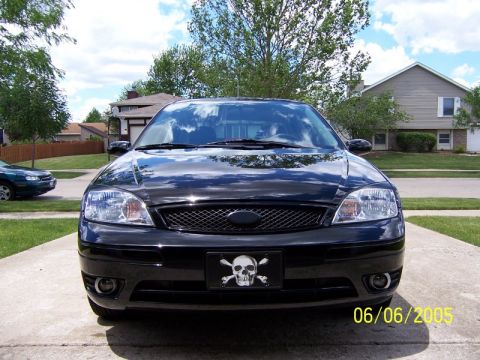 2005 Ford Focus - A black sedan is parked in a driveway, showing its front end and a decorative license plate frame.