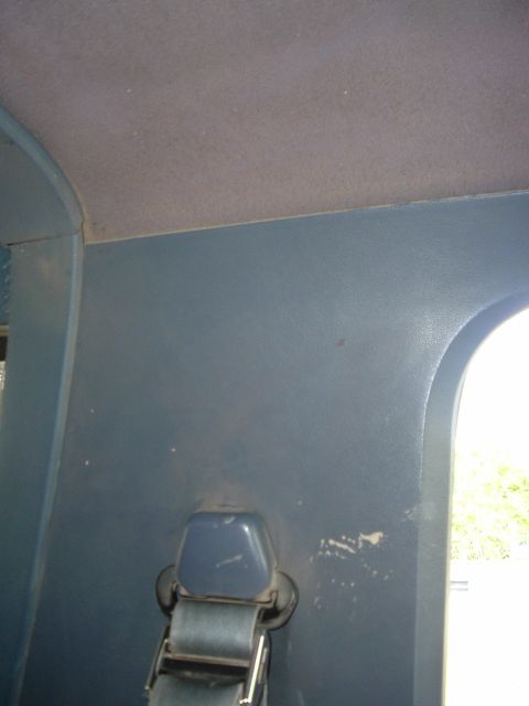 1989 Ford Bronco - The interior of a vehicle is shown, focusing on the side paneling and a seatbelt.