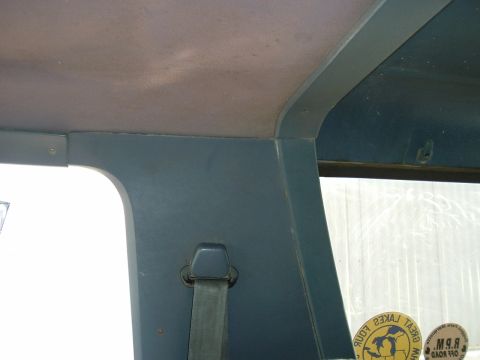 1989 Ford Bronco - Close-up view of the interior trim and a seatbelt, with a sticker visible on the window.