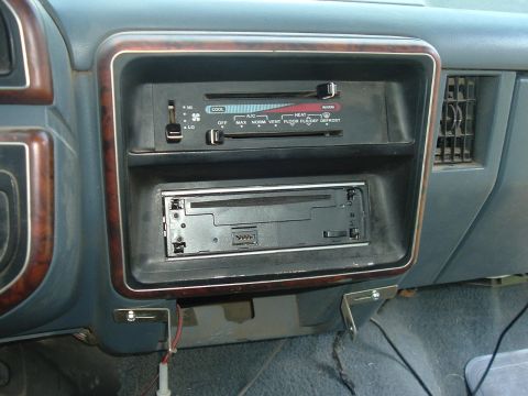 1989 Ford Bronco - The dashboard of a car shows climate controls and a radio slot, with visible text indicating various functions.