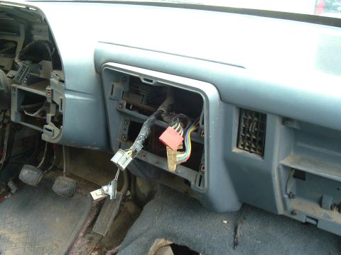 1989 Ford Bronco - The interior of a vehicle shows exposed wiring and connectors in the dashboard area, with pedals visible on the floor.
