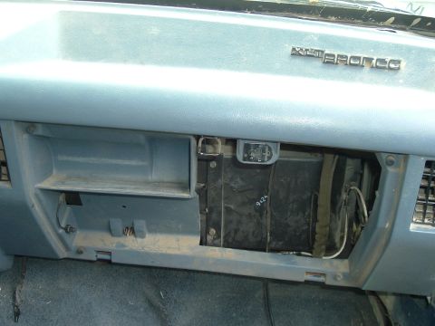 1989 Ford Bronco - Interior view of a 1989 Ford Bronco dashboard, revealing the glove compartment and a prominent "BRONCO" emblem.