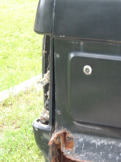 1989 Ford Bronco - The rear corner of the vehicle displays extensive rust damage and a missing taillight assembly.