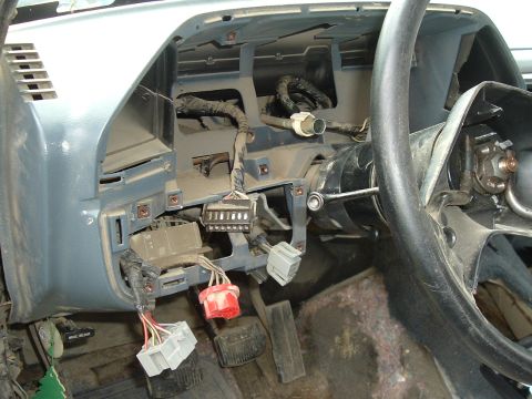 1989 Ford Bronco - Dashboard and steering column removed, showing wiring harness and connectors.