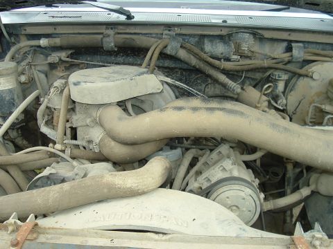 1989 Ford Bronco - The engine bay is covered in dust and grime, obscuring specific details.