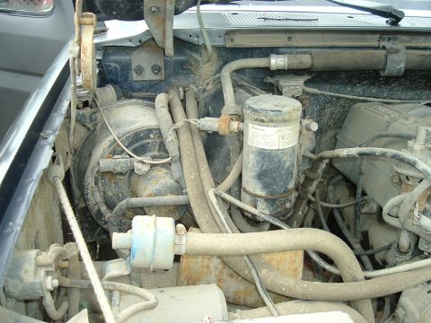 1989 Ford Bronco - Close-up view of the engine bay, showing various hoses and air conditioning components.
