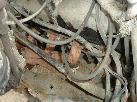 1989 Ford Bronco - Close-up view of engine components, including exhaust manifold and wiring.