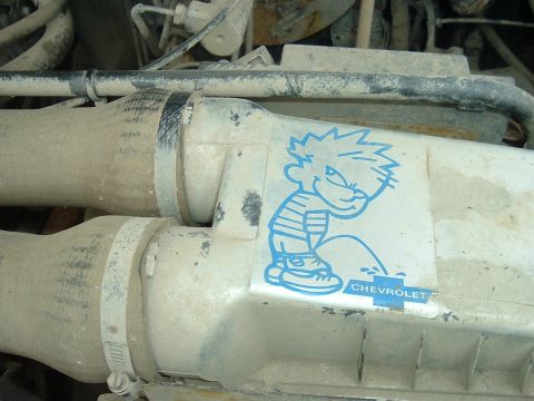 1989 Ford Bronco - This engine bay features a sticker of Calvin from the comic strip, humorously depicted urinating on a Chevrolet logo.