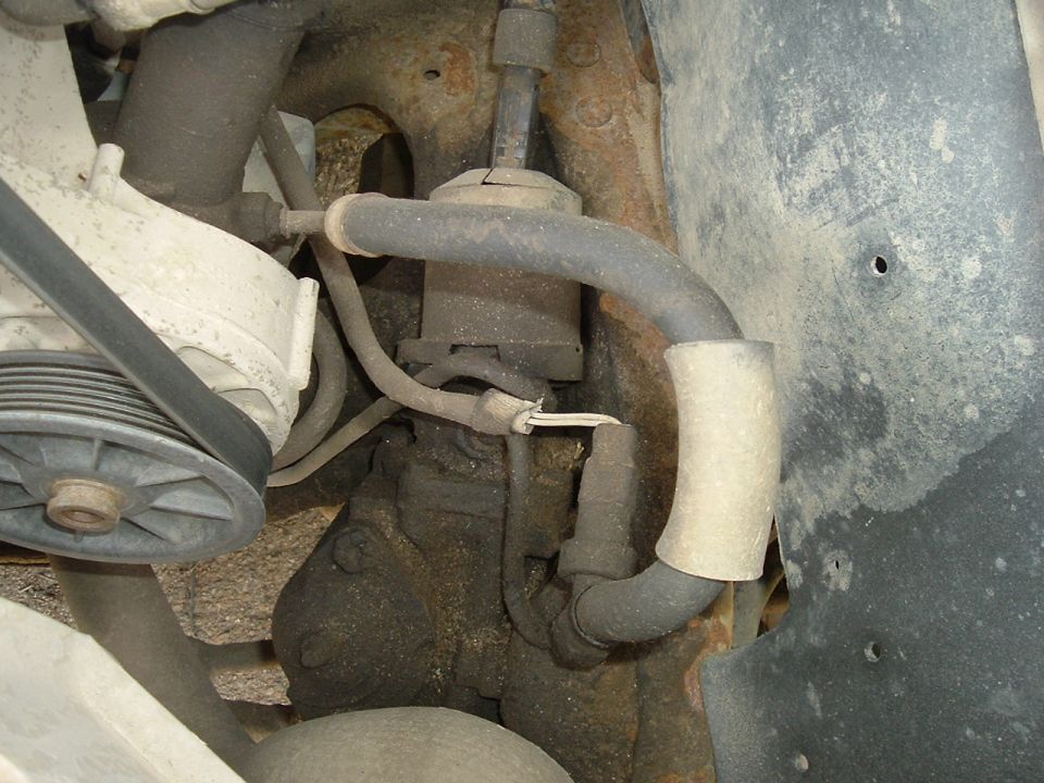 close-up of vehicle's power steering pump and hoses