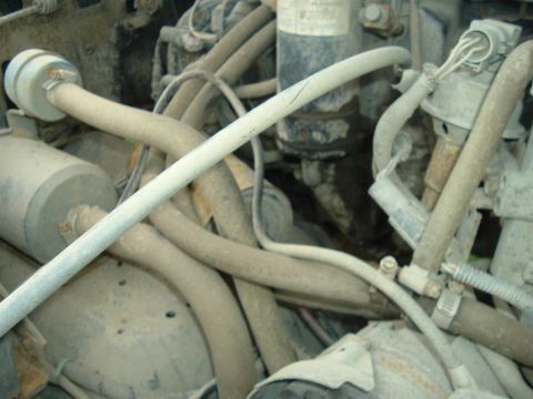1989 Ford Bronco - A close-up view of a cluttered engine compartment, showing various hoses and electrical connections.