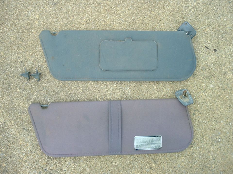 Two car sun visors, one gray, one purple, with a label on the purple one