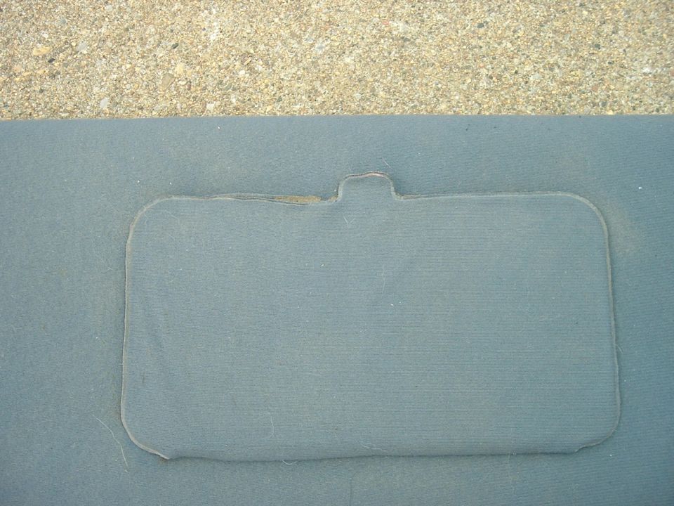 Close-up of a gray interior door panel with a rectangular cutout and a tab at the top. Supermotors.net logo visible