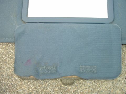 1989 Ford Bronco - A close-up of a vehicle's sun visor, revealing its texture and a small mirror.