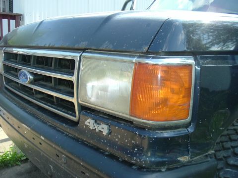 1989 Ford Bronco - Close-up of the front grille and headlight assembly of a 1989 Ford Bronco.