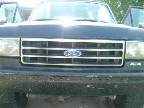 1989 Ford Bronco - The front grille and headlights of a Ford truck are shown with the doors open.