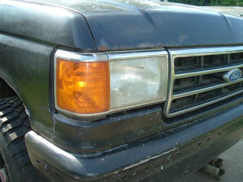 1989 Ford Bronco - Front view of a 1989 Ford Bronco, showing the headlight, amber turn signal, and grille detail.