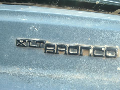 1989 Ford Bronco - Close-up of an XLT Bronco emblem, indicating a specific trim level.