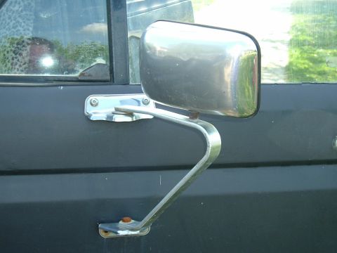 1989 Ford Bronco - A close-up view of a vehicle's side mirror and door panel, showing details of the exterior.