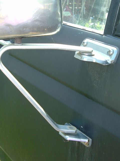 1989 Ford Bronco - Close-up of a vehicle's side mirror assembly, showing the metal arm and mounting bracket.