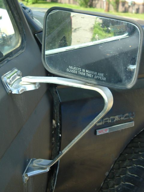 1989 Ford Bronco - Side mirror and 'Bronco XLT' badging visible on the dark exterior of a 1989 Ford Bronco.